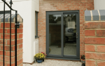 A grey uPVC patio door on a brick house.